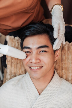 Satisfied male client receiving a 2D HIFU facial session in an aesthetic clinic for noninvasive skin tightening and rejuvenation.