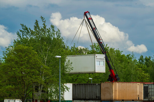 Ein B&uuml;rocontainer wird mit einem mobilen Kran angehoben