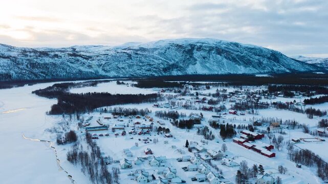 Alta, Norway. Aerial view of small northern town Alta, Norway in winter. Aerial time-lapse with houses, river and mountain in the evening, zoom in