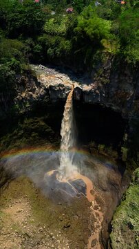Cinematic aerial view of Kapas Biru waterfall in East Java &ndash; Breathtaking drone shot of the dramatic jungle canyon and majestic cascade during beautiful morning sunrise in Indonesia 4k