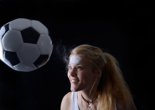 Young woman heading soccer ball