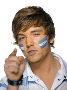 Young man with Argentina's flag painted on face, close-up