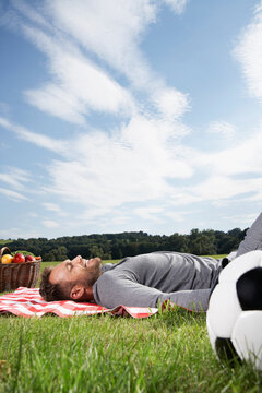 Germany, Cologne, Man relaxing on picnic blanket