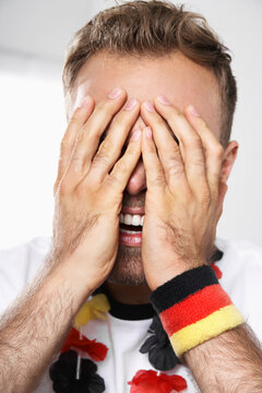 Excited soccer fan covering his eyes