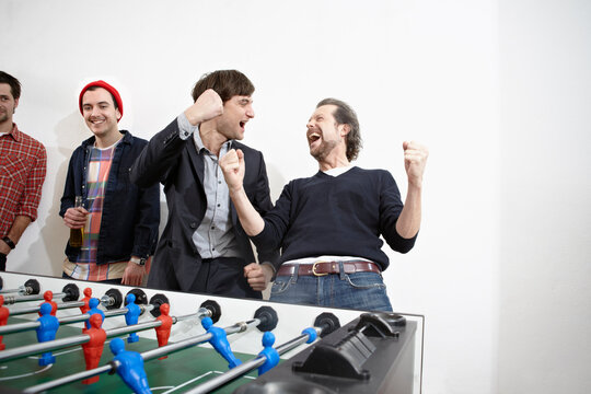 Germany, Cologne, Men playing table soccer