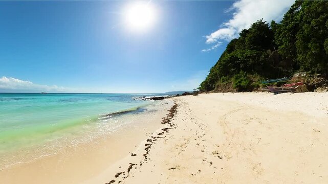 Turquoise waves on sandy beach in Boracay Island. Blue sky and clouds. Philippines.