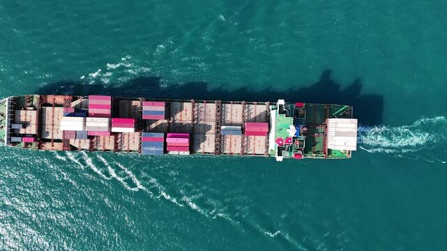 cargo container ship fully loaded with pink and red containers, assisted by a tugboat in the turquoise ocean. Global maritime logistics and supply chain concept.	international trade, and heavy ship