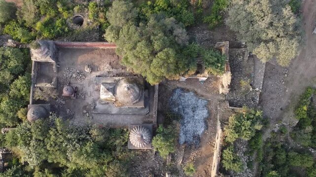 Tilla jogian Pakista tilt shot drone video showing sikh temple ruins courtyard well and domed shrines from above