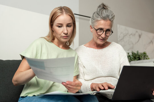 Young adult daughter helps senior mother with important documents