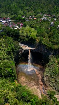 Epic cinematic tracking shot over majestic Kapas Biru canyon &ndash; Hidden tropical paradise waterfall with roaring cascade and morning sun rays, professional marketing video for travel tourism