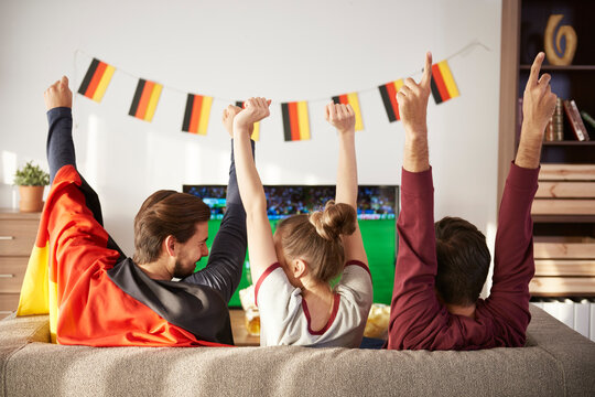 German football fans watching Tv and cheering