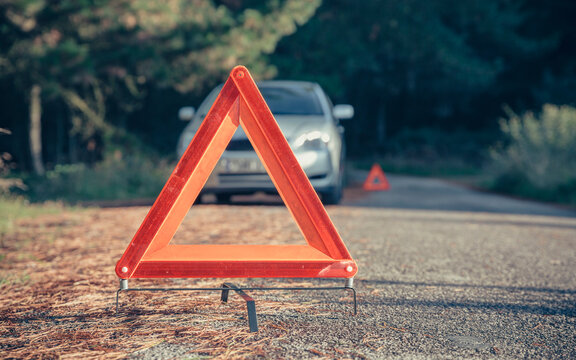 Warning triangle in the road by a car breakdown
