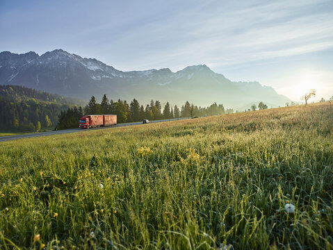 Austria, Tyrol, truck on country road in the morning light