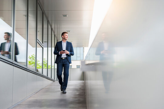 Young businessman with cell phone in the city on the