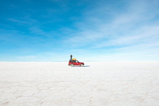 Bolivia, Atacama, Altiplano, Salar de Uyuni, Man standing on a 4x4 car