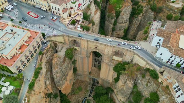 Spectacular view of the historic Puente Nuevo stone bridge in Ronda, Andalusia. Iconic medieval architecture spanning across the deep El Tajo gorge with whitewashed cliffside houses in Spain.