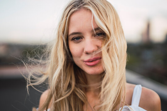 Portrait of smiling blond young woman outdoors