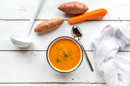 Bowl of sweet potato carrot soup garnished with cress