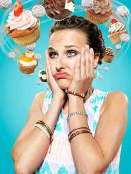 Young woman with flying cupcakes around her head, Composite