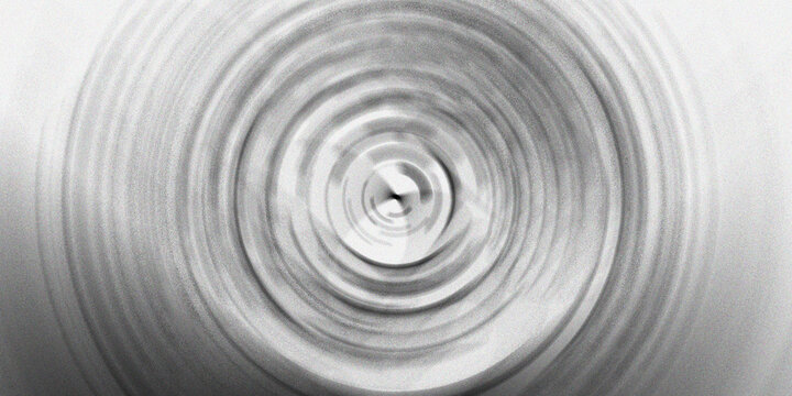 Abstract concentric circles spinning motion blur background with radial lines and grayscale gradient effect.