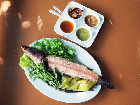 Grilled striped snakehead fish served with boiled mixed vegetable such as eggplant, normally dip with spicy seafood sauce.