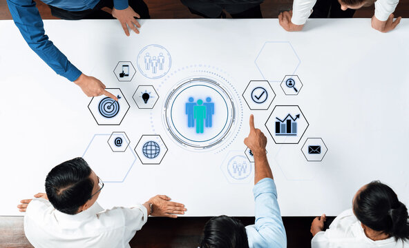 A diverse group of professionals actively engaged in a collaborative meeting, utilizing a digital interface to explore business strategies and data-driven insights. Trope