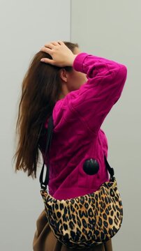 Woman rehearsing runway moves confidently. Woman adjusting her stance in dressing room with fierce confidence. Female model rehearing runway walk with energetic gestures and bold attitude