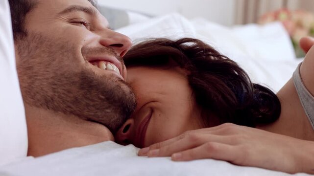 Couple, cuddle and relax on bed in home, love and affection for partner and commitment for marriage. Happy people, resting and embrace with spouse in bedroom, man and bonding with woman or romance