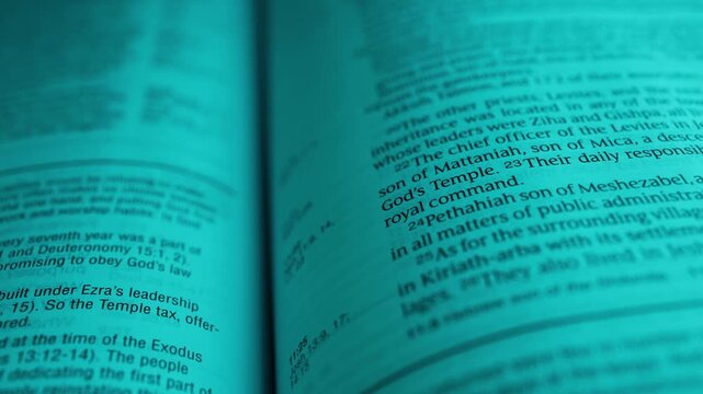 Macro close-up of open Bible pages features highlighted text and a detailed map under cool teal lighting. The camera moves smoothly, emphasizing typography, paper texture, and scholarly ambiance.