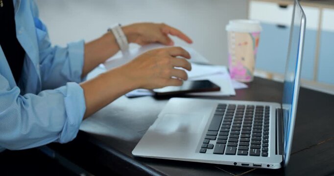 Sorting envelopes and bills on desk. Individual arranging invoices and documents at workspace. Worker managing envelopes and financial documents during administrative process at office desk