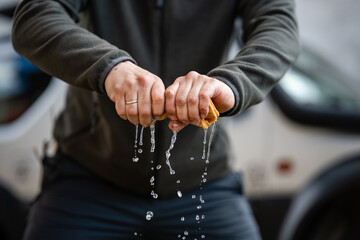 Hands wringing wet cloth squeezing out water © Zoran Jesic