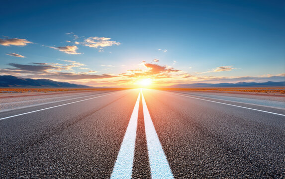 Sunset Roadway Leading Towards Golden Horizon Amidst Clear Skies and Distant Mountains