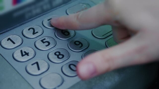 Close-up of a person entering a PIN code on an ATM keypad while withdrawing cash. The footage highlights everyday banking activity, financial transactions, and security awareness. High quality 4k