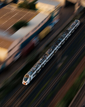 Aerial view of a modern passenger train speeding along tracks with motion blur effect in Dakar, Dakar Region, Senegal.