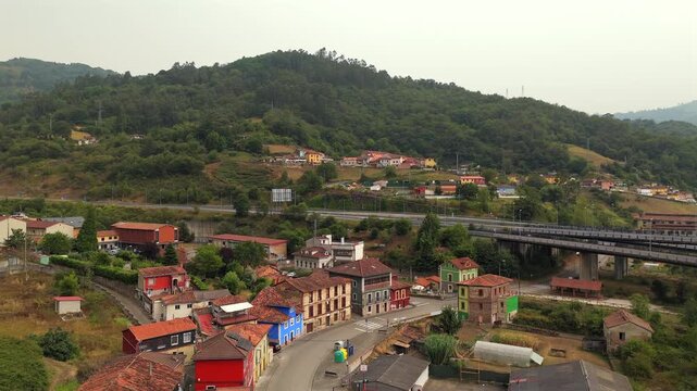 Drone aerial view of colorful mountain houses and green valley near La Pena Asturias