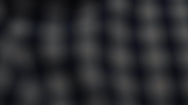 Blurred dark plaid fabric texture background with bokeh effect