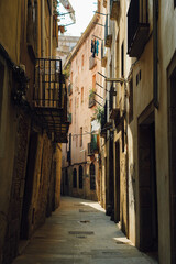Fototapeta premium Narrow cobblestone street with old buildings and balconies in Gothic Quarter of Barcelona