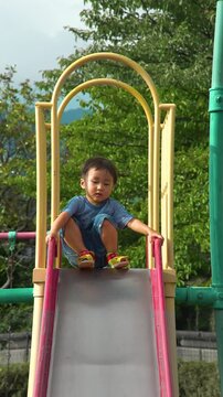 滑り台をする男の幼稚園児