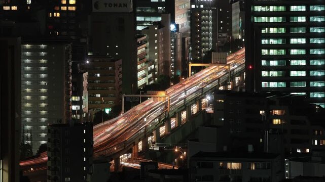 夜の首都高をライトを点けて行き交う車郡を俯瞰する