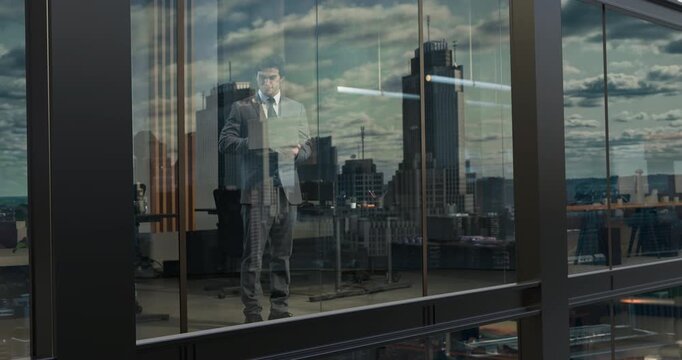Male Entrepreneur Stands Inside Modern Office Operating Open Laptop Beside Reflective Glass Window, Reviewing Digital Analytics, Cloud Computing Data and Managing Enterprise Software Workflow.
