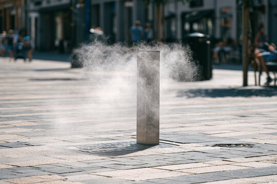 Urban cooling mist system operating on a hot summer day, representing heatwave adaptation, public cooling infrastructure and climate resilience in the city