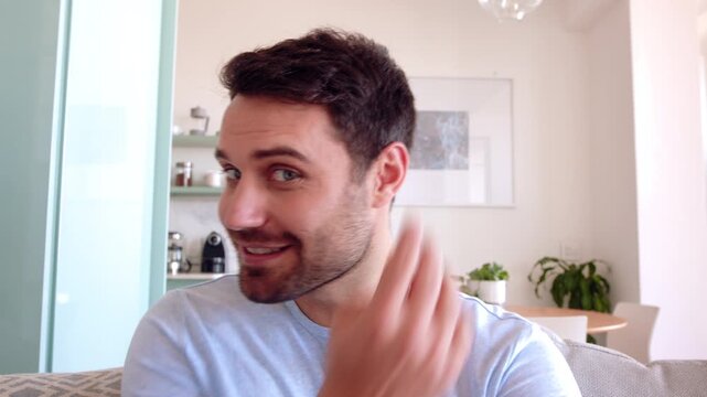 Face, man and live stream in home with wave, hair care influencer or grooming tips for social media. Happy, person talk and online broadcast with virtual chat, POV and content creation for hairstyle.