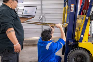 Technicians analyzing data for forklift maintenance and repair © Apichat