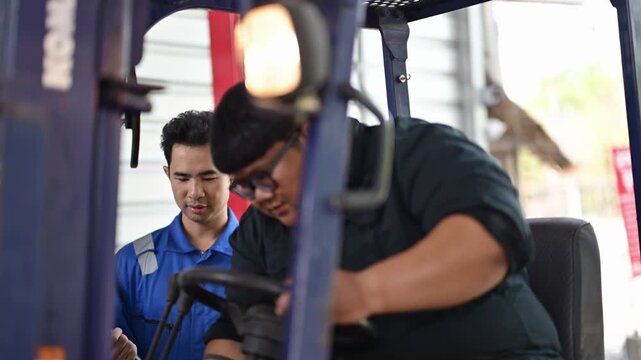 Warehouse supervisor training new forklift driver