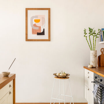 Minimalist Kitchen Interior with Abstract Art, Bamboo Plant, and Autumnal Decor on Countertops
