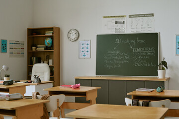 Wide shot of empty classroom displaying chalkboard lesson on 3D modeling basics, supporting digital education and coding curriculum © AnnaStills