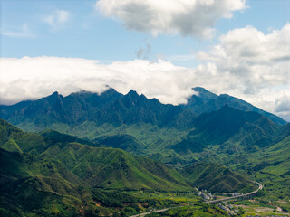 Fototapeta premium A scenic landscape view of the lush green mountains in Wuyi Mountain located in Fujian China with clouds hanging over the mountain peaks