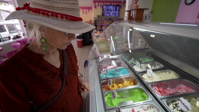 Mature woman visits an ice cream shop in Santa Rosalia Baja California and looks at various flavors available for tasting
