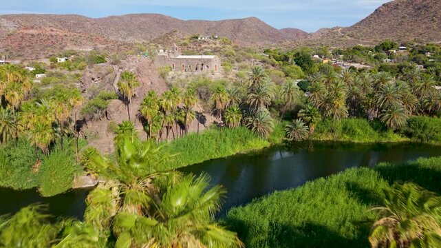 Aerial views show the mission of Santa Rosalia of Mulege with surrounding mountains, desert, and lush oasis on a late afternoon in Baja Mexico.