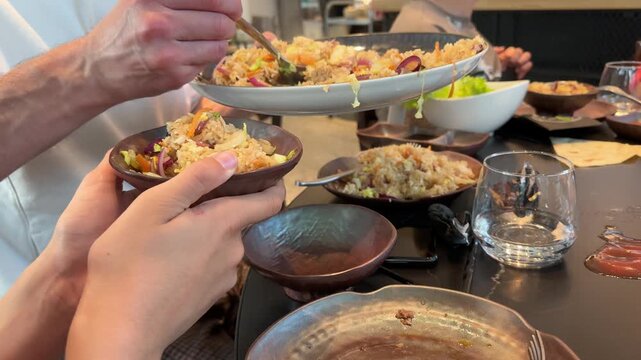 People hands using metal tongs serving fried rice, grilling on hot metal plate, japanese yakiniku, Korean BBQ cooking process, Fresh restaurant ingredients, delicious food appetizing meal gourmet food